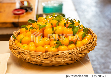 Luk Chup or Look Choop, the marzipan mung beans dessert in Thai style, molded in miniature orange fruit shape arranged in wicker basket. Luk Chup or Look Choop, the marzipan mung beans dessert in Thai style, molded in miniature orange fruit shape arranged in wicker basket. 139703718