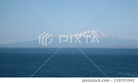 A photograph of the snow-capped Mt. Chokai against a clear blue sky. A photograph of the snow-capped Mt. Chokai against a clear blue sky. 139703942