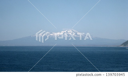A photograph of the snow-capped Mt. Chokai against a clear blue sky. 139703945