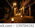 Blue cobblestone street illuminated with lights; no people around. 139704192