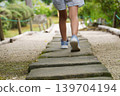 The back view of a girl walking across a stone 139704194