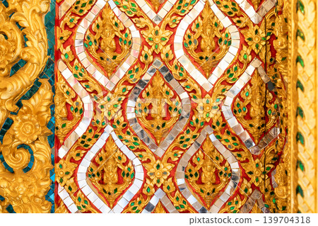 Close view ornate temple door golden thepphanom figure high relief layered carving sacred Thai ornament craftsmanship. Close view ornate temple door golden thepphanom figure high relief layered carving sacred Thai ornament craftsmanship. 139704318