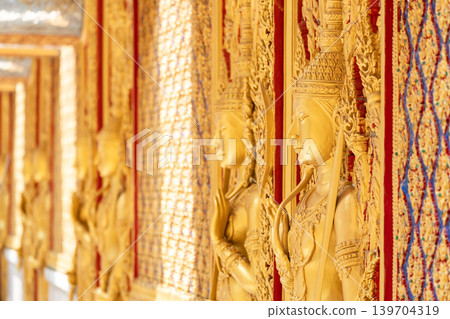 Close view ornate temple door golden thepphanom figure high relief layered carving sacred Thai ornament craftsmanship. Close view ornate temple door golden thepphanom figure high relief layered carving sacred Thai ornament craftsmanship. 139704319