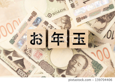 一塊寫著「新年壓歲錢」的鈔票和許多1萬日圓面額的鈔票。 一塊寫著「新年壓歲錢」的鈔票和許多1萬日圓面額的鈔票。 139704406