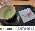 The set of matcha tea and Japanese sweets is placed on a black tray. 139704613