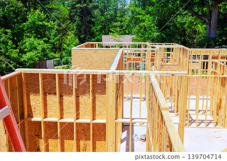 Building new homes at construction site on unfinished house residential area framing stage 139704714