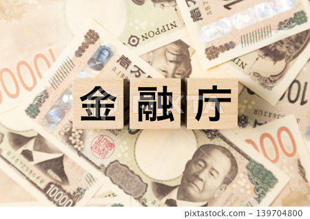 A block with "Financial Services Agency" written on it and lots of 10,000 yen bills. 139704800