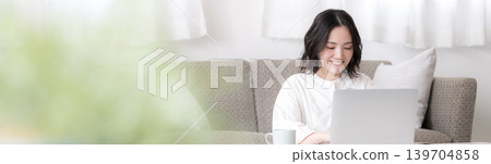 A woman who uses her laptop at home, studying for qualifications and considering investments – a lifestyle that involves working with a smile (banner image). A woman who uses her laptop at home, studying for qualifications and considering investments – a lifestyle that involves working with a smile (banner image). 139704858