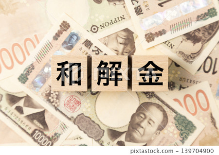 一塊寫著「和解金」字樣的鈔票和許多10,000日圓面額的鈔票。 一塊寫著「和解金」字樣的鈔票和許多10,000日圓面額的鈔票。 139704900