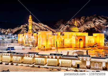 The illuminated Sayyid Al Shuhada Mosque stands at the base of Mount Uhud in Madinah, Saudi Arabia, showcasing Islamic architecture under a night sky. The illuminated Sayyid Al Shuhada Mosque stands at the base of Mount Uhud in Madinah, Saudi Arabia, showcasing Islamic architecture under a night sky. 139705039