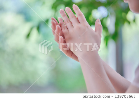 一位年輕女子正在照顧她的雙手，照片中可以看到她的身體部位。 139705665