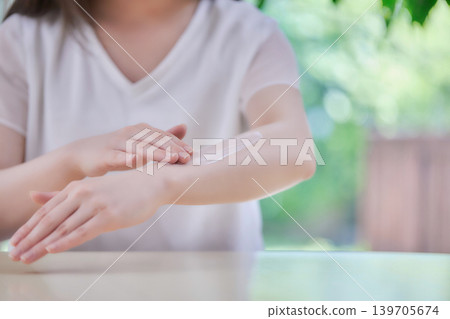 A woman in her 20s applying sunscreen. A woman in her 20s applying sunscreen. 139705674