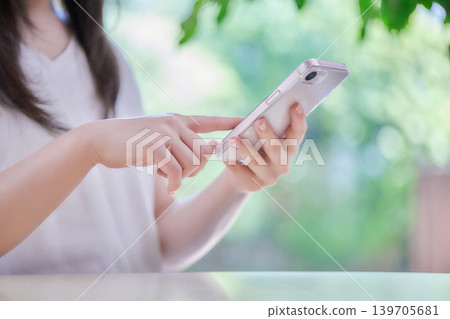 一位年輕女子在房間裡看著她的智慧型手機 一位年輕女子在房間裡看著她的智慧型手機 139705681