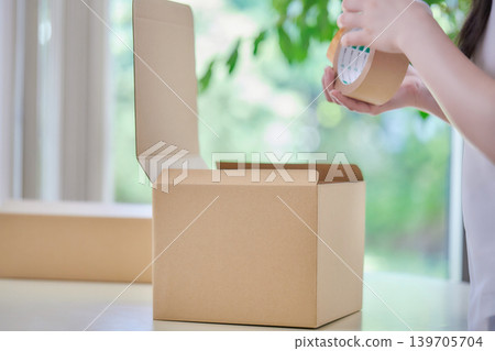 A young woman making cardboard boxes 139705704