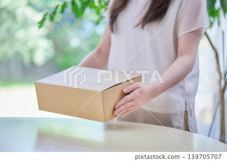 A young woman making cardboard boxes A young woman making cardboard boxes 139705707
