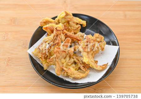 Tempura of maitake mushrooms served on a black plate. Tempura of maitake mushrooms served on a black plate. 139705738
