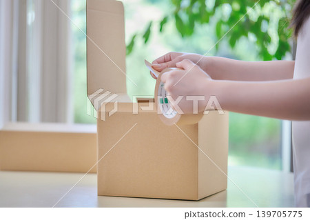 A young woman making cardboard boxes 139705775