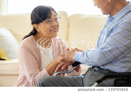 一位坐在輪椅上的老人和一位照顧他的女士。 139705958