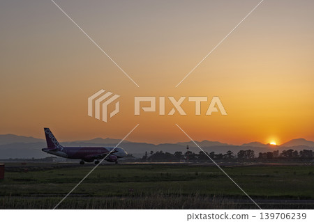 Sendai Airport at dusk: A plane taxiing against the setting sun, Natori City, Miyagi Prefecture. Sendai Airport at dusk: A plane taxiing against the setting sun, Natori City, Miyagi Prefecture. 139706239