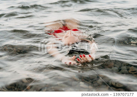 Woman, water, relaxation, peaceful woman floating on her back in calm water during summer vacation. Woman, water, relaxation, peaceful woman floating on her back in calm water during summer vacation. 139707177