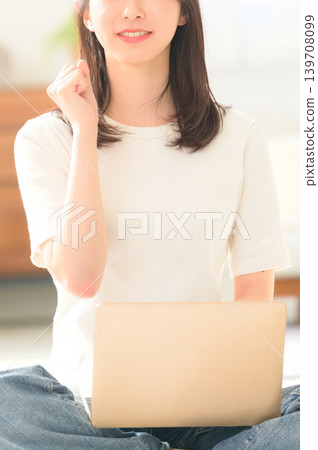 Japanese woman holding a laptop and making a triumphant gesture Japanese woman holding a laptop and making a triumphant gesture 139708099