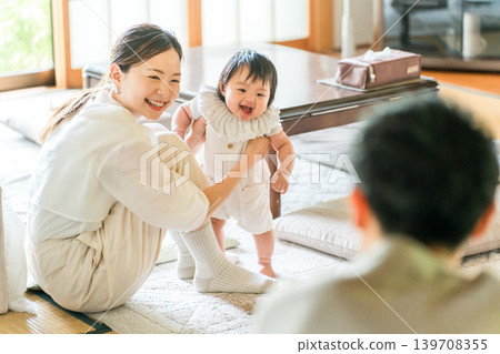 一個嬰兒正在學習扶著東西站立,一個幼兒正在練習走路,以及他們的母親。 一個嬰兒正在學習扶著東西站立,一個幼兒正在練習走路,以及他們的母親。 139708355