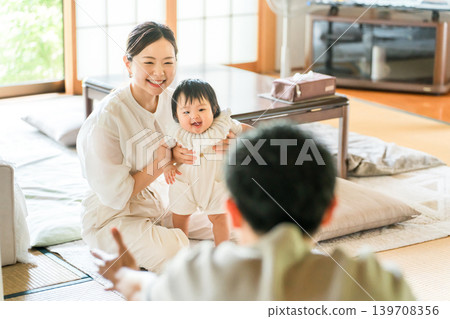 一個嬰兒正在學習扶著東西站立，一個幼兒正在練習走路，以及他們的母親。 139708356