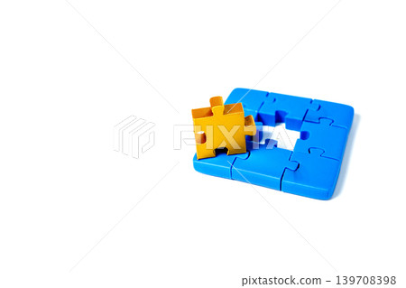 A single Gold jigsaw puzzle piece stands on top of several connected blue pieces with one missing in the middle. Concept of unique solution, leadership, or business strategy on white background. 139708398