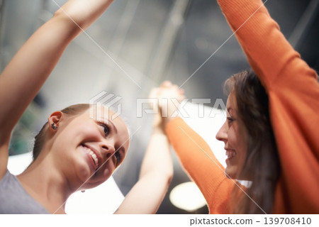 Women, friends and holding hands with bonding, care and love at a concert with a smile. Happy, people and music festival at event with excited, support and students together at a party with low angle Women, friends and holding hands with bonding, care and love at a concert with a smile. Happy, people and music festival at event with excited, support and students together at a party with low angle 139708410