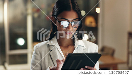 Tablet, reflection and woman in office with glasses, overtime with planning and scroll on social media. Vision, research and businesswoman typing email, late at night work on future ideas for agency. Tablet, reflection and woman in office with glasses, overtime with planning and scroll on social media. Vision, research and businesswoman typing email, late at night work on future ideas for agency. 139708497
