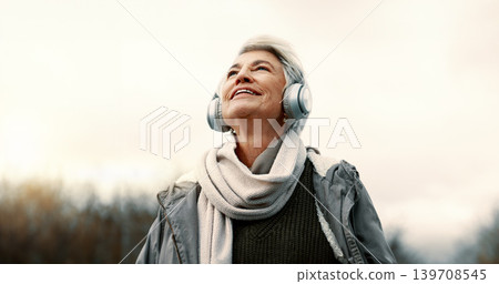 Headphones, music and senior woman in nature for wellness, mental health and happy outdoor experience. Travel, listening and streaming service or podcast of elderly person thinking in park and winter Headphones, music and senior woman in nature for wellness, mental health and happy outdoor experience. Travel, listening and streaming service or podcast of elderly person thinking in park and winter 139708545