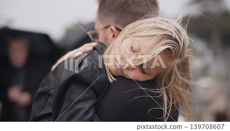 Sad, death and a daughter with her father at a funeral for grief or mourning loss together outdoor. Family, empathy and a man holding his girl child at a memorial service or ceremony for condolences Sad, death and a daughter with her father at a funeral for grief or mourning loss together outdoor. Family, empathy and a man holding his girl child at a memorial service or ceremony for condolences 139708607
