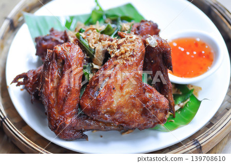 fried chick with fried garlic or chicken wings or deep fried chicken , fried chicken and sauce 139708610