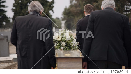 Men, coffin and pallbearers walking at cemetery ceremony outdoor at burial tomb. Death, grief and group casket at funeral, carry to graveyard and family service of people mourning at windy event. Men, coffin and pallbearers walking at cemetery ceremony outdoor at burial tomb. Death, grief and group casket at funeral, carry to graveyard and family service of people mourning at windy event. 139708644
