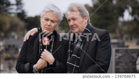 Funeral, graveyard and sad senior couple hug for comfort, empathy and support at memorial service. Depression, grief and man and woman embrace with flower for goodbye, mourning and burial for death Funeral, graveyard and sad senior couple hug for comfort, empathy and support at memorial service. Depression, grief and man and woman embrace with flower for goodbye, mourning and burial for death 139708675
