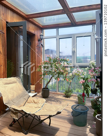 A sunroom (inner balcony) of a detached house with a relaxation chair. 139710102