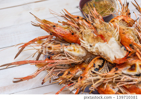 Closeup of grilled river prawns served spicy dipping sauce showcasing fresh seafood texture traditional cuisine 139710381