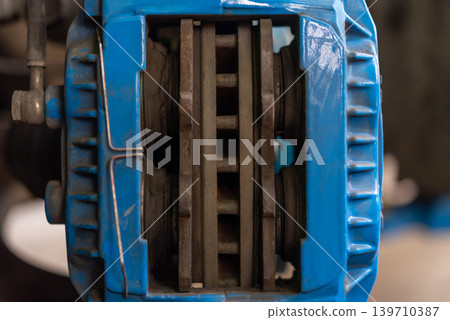 Closeup of industrial brake caliper disc system showing mechanical engineering details automotive maintenance components 139710387