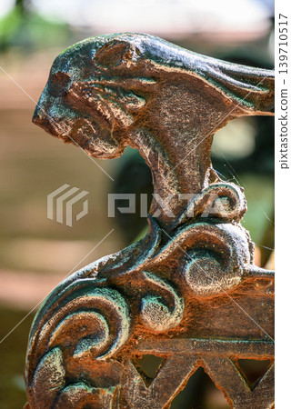 Weathered ornamental metal sculpture detail with patina 139710517