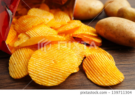 Potato chips in open bag, delicious BBQ seasoning spicy for crips, thin slice deep fried snack fast food. Potato chips in open bag, delicious BBQ seasoning spicy for crips, thin slice deep fried snack fast food. 139711304