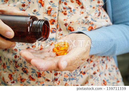 Asian elderly woman holding pill drug in hand, strong healthy medical. 139711339