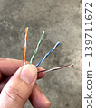 Hand holds untwisted Ethernet cables 139711672