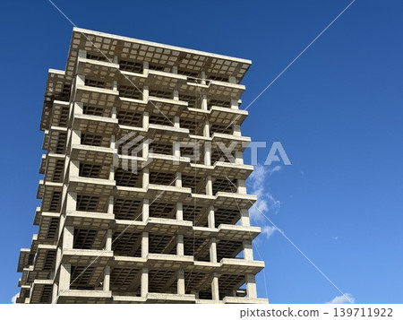 Unfinished concrete building against clear blue sky background 139711922