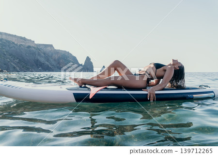 Woman Paddleboard Ocean Relaxing on Paddleboard in Calm Water Woman Paddleboard Ocean Relaxing on Paddleboard in Calm Water 139712265