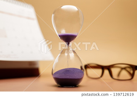 Hourglass with reading glasses and calendar, senior lifestyle, aging vision Hourglass with reading glasses and calendar, senior lifestyle, aging vision 139712619