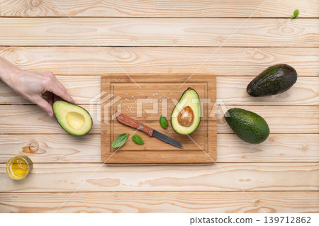 Hand holding avocado healthy cooking ingredients Hand holding avocado healthy cooking ingredients 139712862