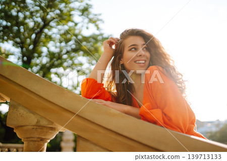 Female tourist in bright dress enjoys sights of the city on sunny day. Concept of lifestyle, fashion 139713133