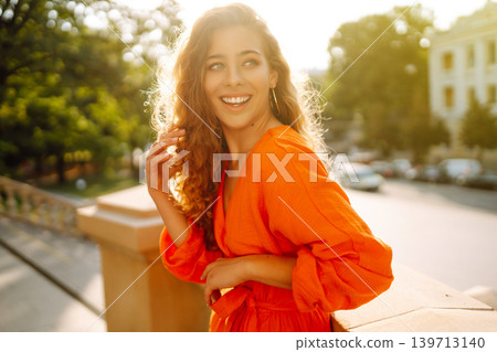 Female tourist in bright dress enjoys sights of the city on sunny day. Concept of lifestyle, fashion 139713140