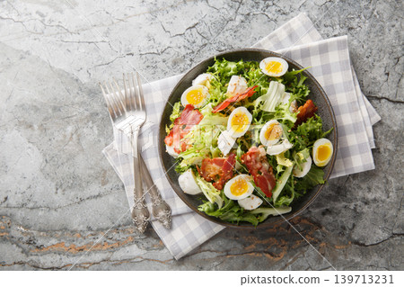 Keto salad with boiled quail eggs, bacon, mozzarella, and mixed lettuce, close-up on a plate. Horizontal top view Keto salad with boiled quail eggs, bacon, mozzarella, and mixed lettuce, close-up on a plate. Horizontal top view 139713231