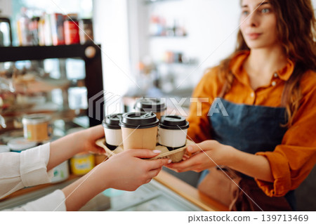 The coffee shop owner gives orders to go. Takeaway drinks concept, small business. The coffee shop owner gives orders to go. Takeaway drinks concept, small business. 139713469
